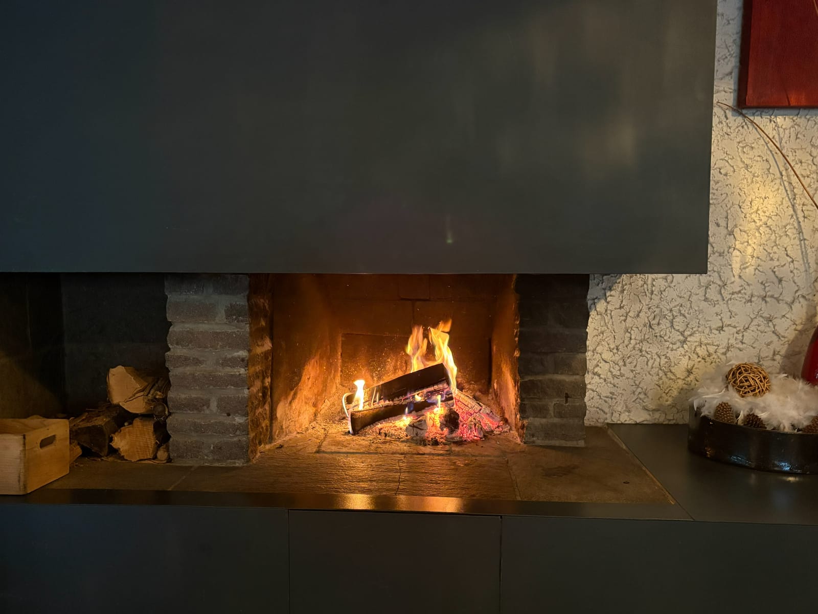 Offener Kamin mit Feuer und Schaffell-Deko – MONTAFONLodge