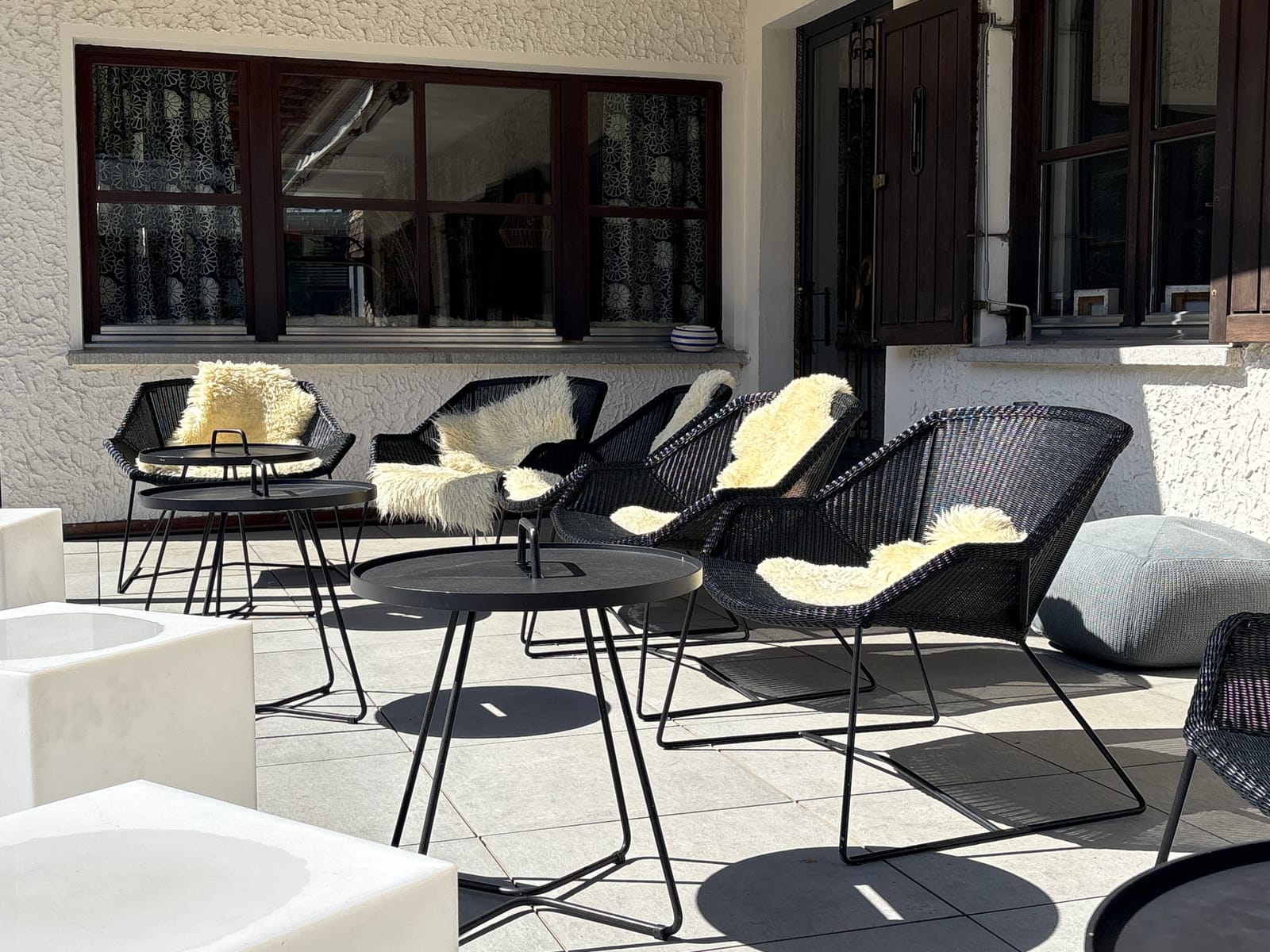 Lounge-Bereich mit Sesseln und Schaffellen an der Fensterfront – MONTAFONLodge