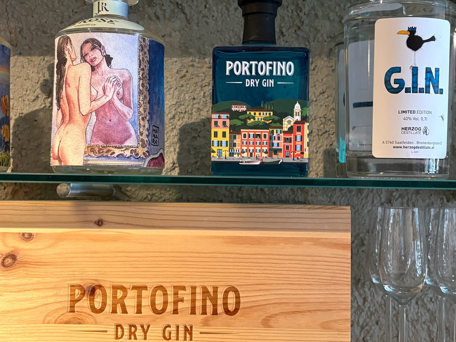 Portofino Dry Gin Flaschen auf Holzkiste an der Bar-Ablage – MONTAFONLodge