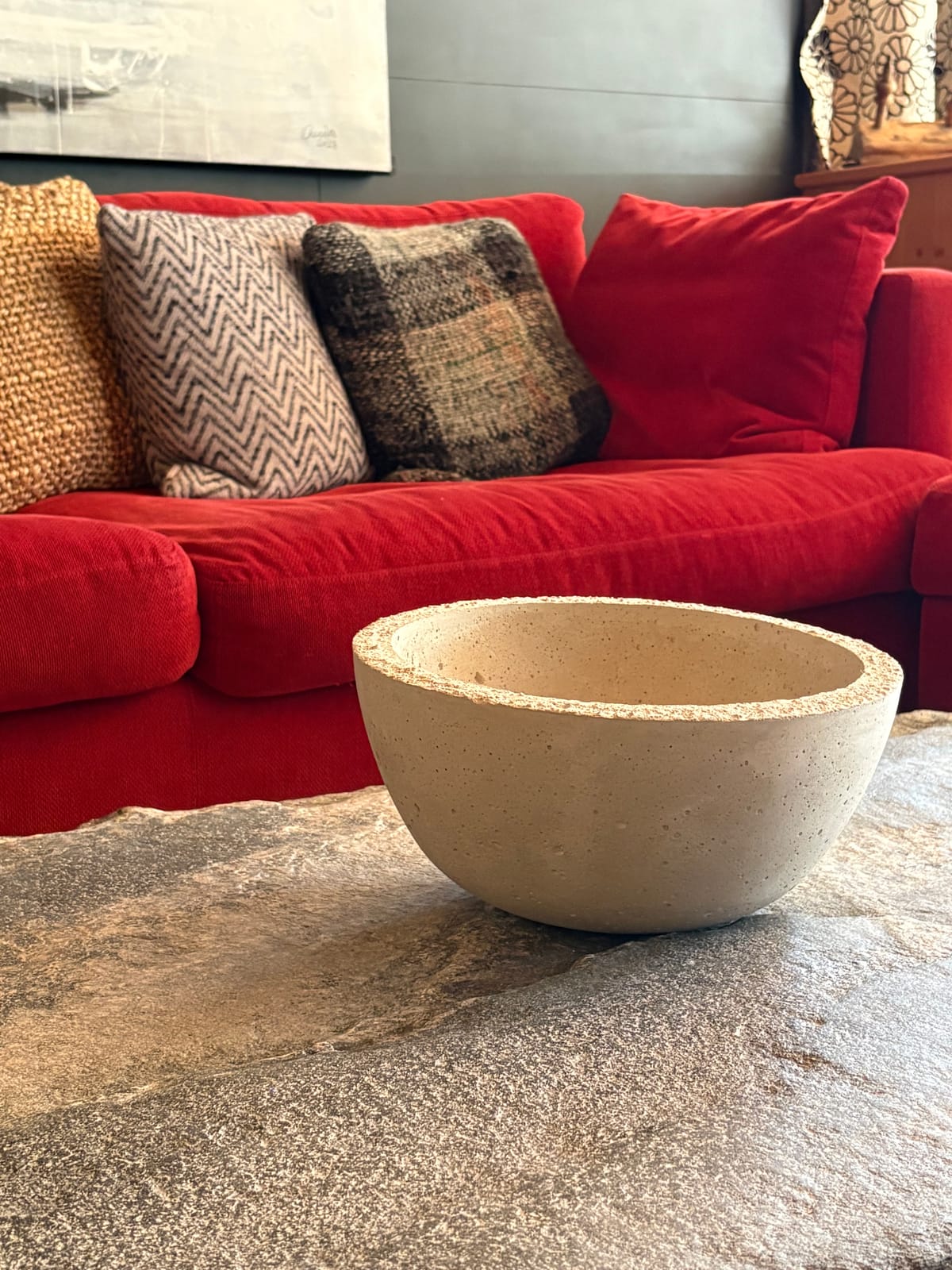 Rotes Sofa mit Kissen und Steinschale, Detailaufnahme – MONTAFONLodge