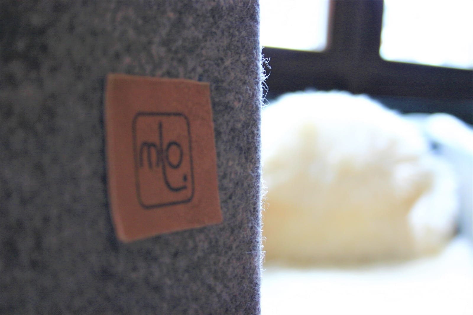 Filz-Detail mit "mo"-Logo und Schaffell, unscharf – MONTAFONLodge