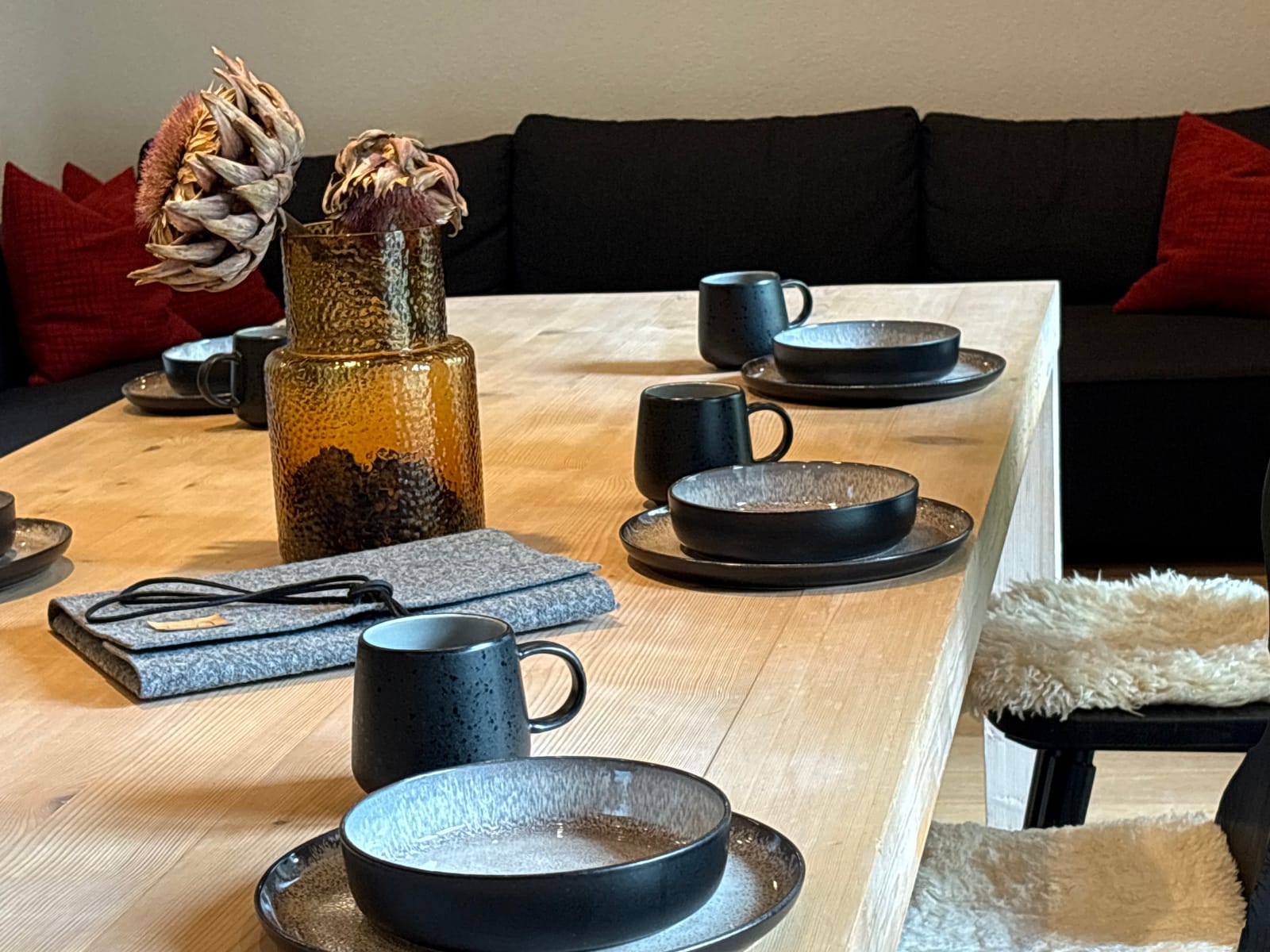 Gedeckter Tisch mit schwarzem Geschirr und Deko-Blumen – MONTAFONLodge