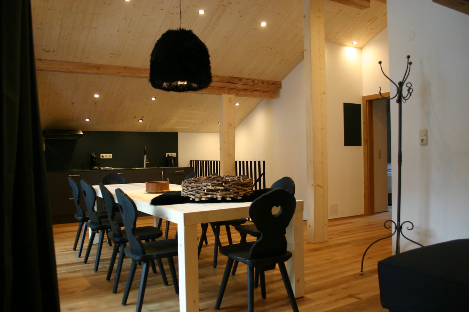 Chalet-Wohnküche mit weißem Esstisch, schwarzen Stühlen und Pendelleuchte – MONTAFONLodge