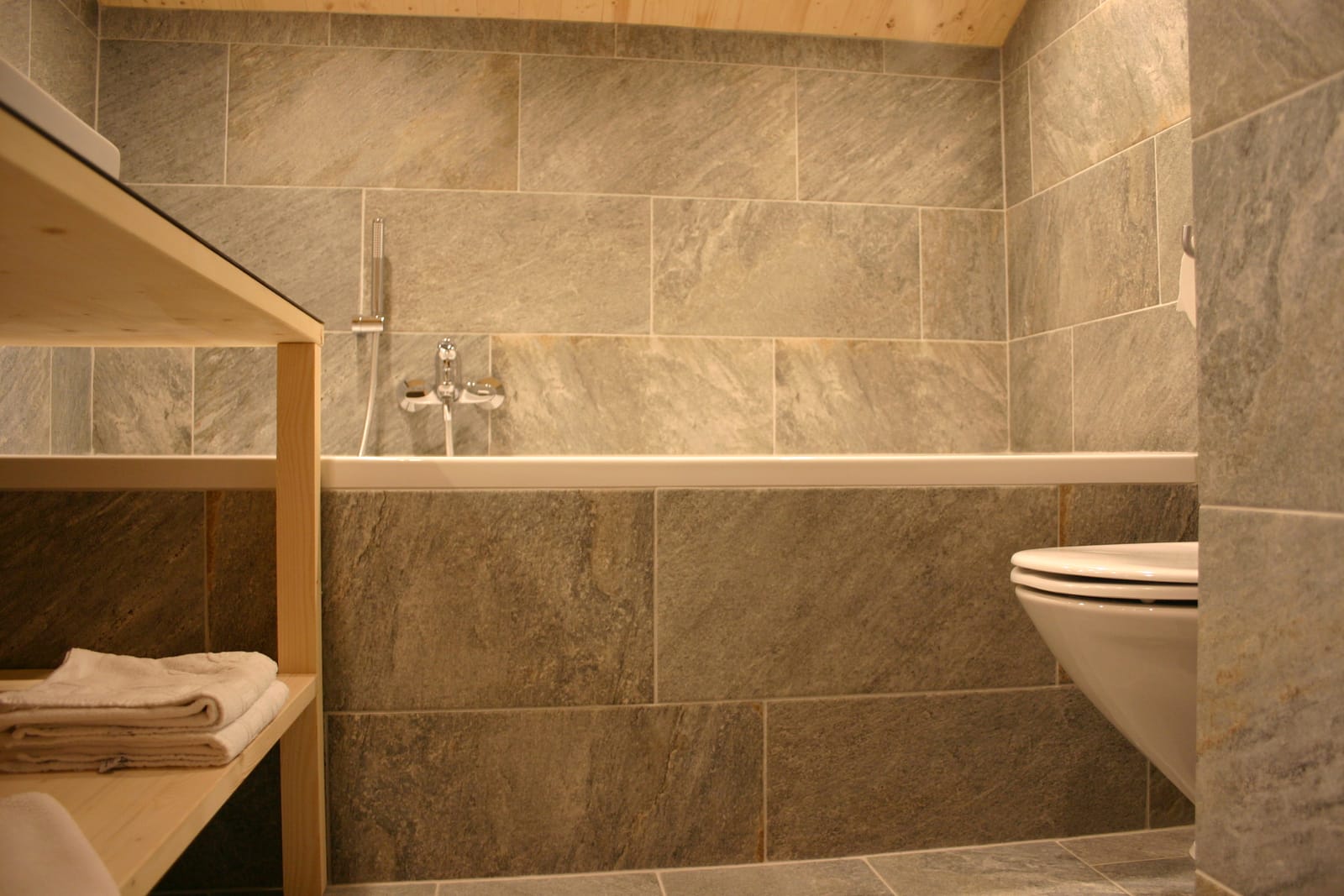 Bad mit Dusche und WC, Steinfliesen – MONTAFONLodge
