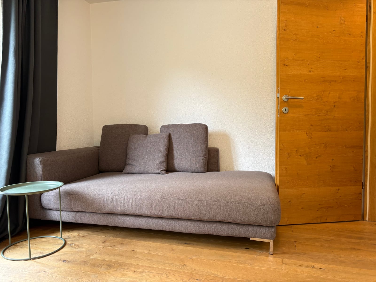 Graues Sofa mit Beistelltisch und Zimmertür – MONTAFONLodge