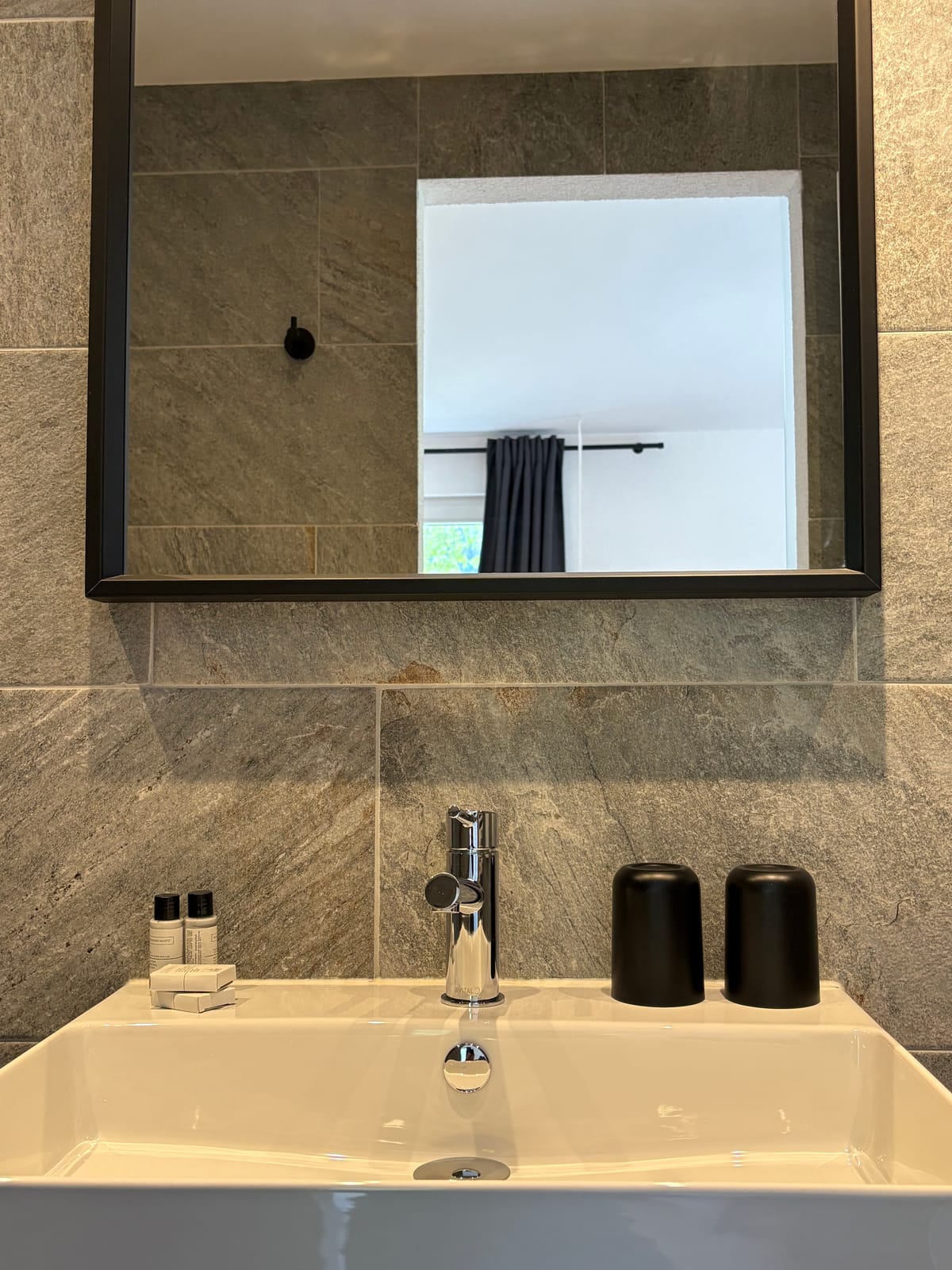 Waschbereich mit Spiegel und Amenities, Steinfliesen – MONTAFONLodge