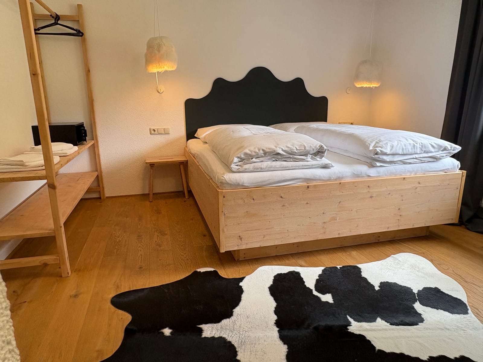 Doppelbett mit Holz-Kopfteil, Fellteppich und Regal/Leiter – MONTAFONLodge