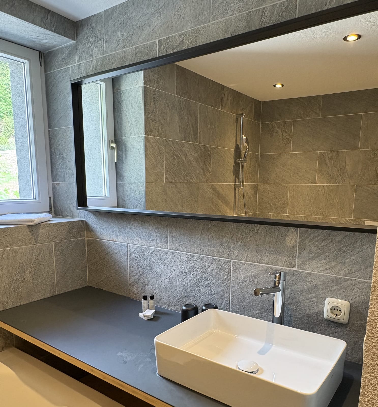 Bad mit Spiegel und Waschbecken, Steinfliesen – MONTAFONLodge