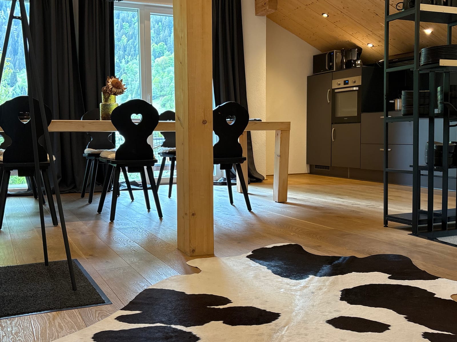 Essbereich mit Tisch und Stühlen, Küche im Hintergrund – MONTAFONLodge