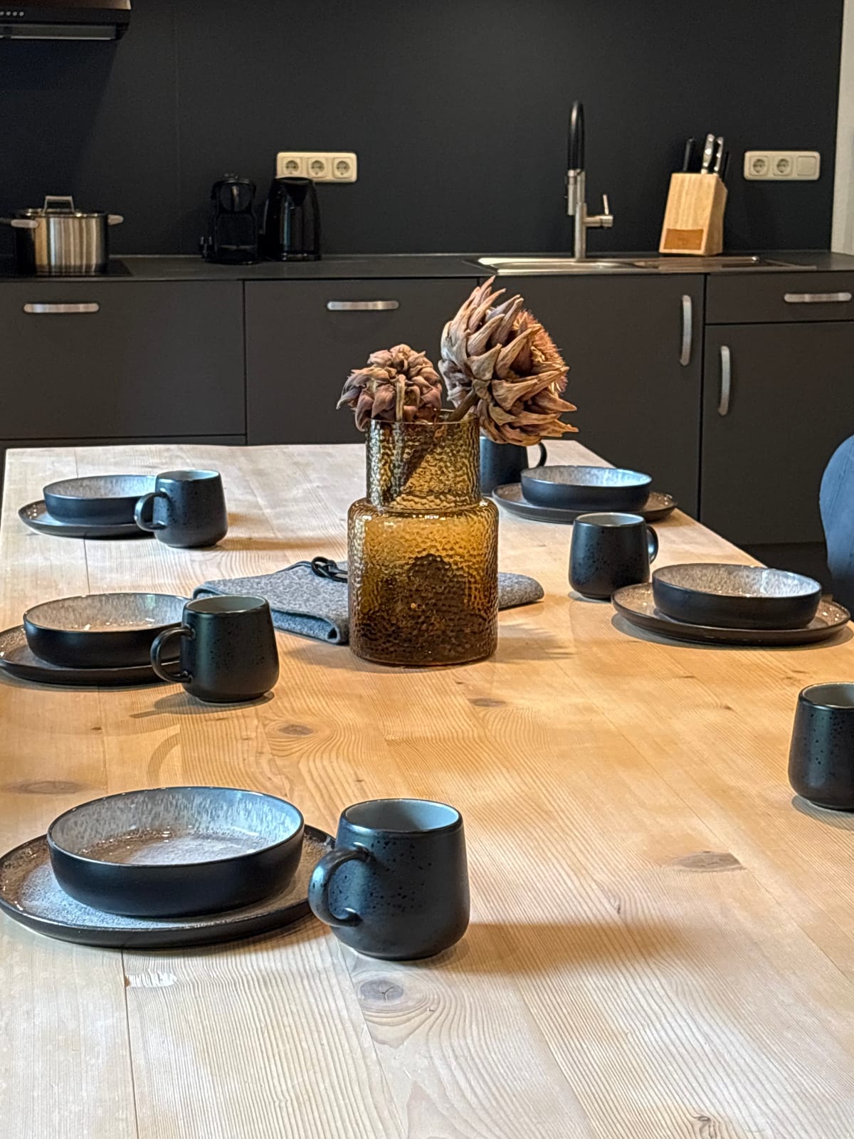 Gedeckter Tisch mit schwarzem Geschirr vor der Küche – MONTAFONLodge