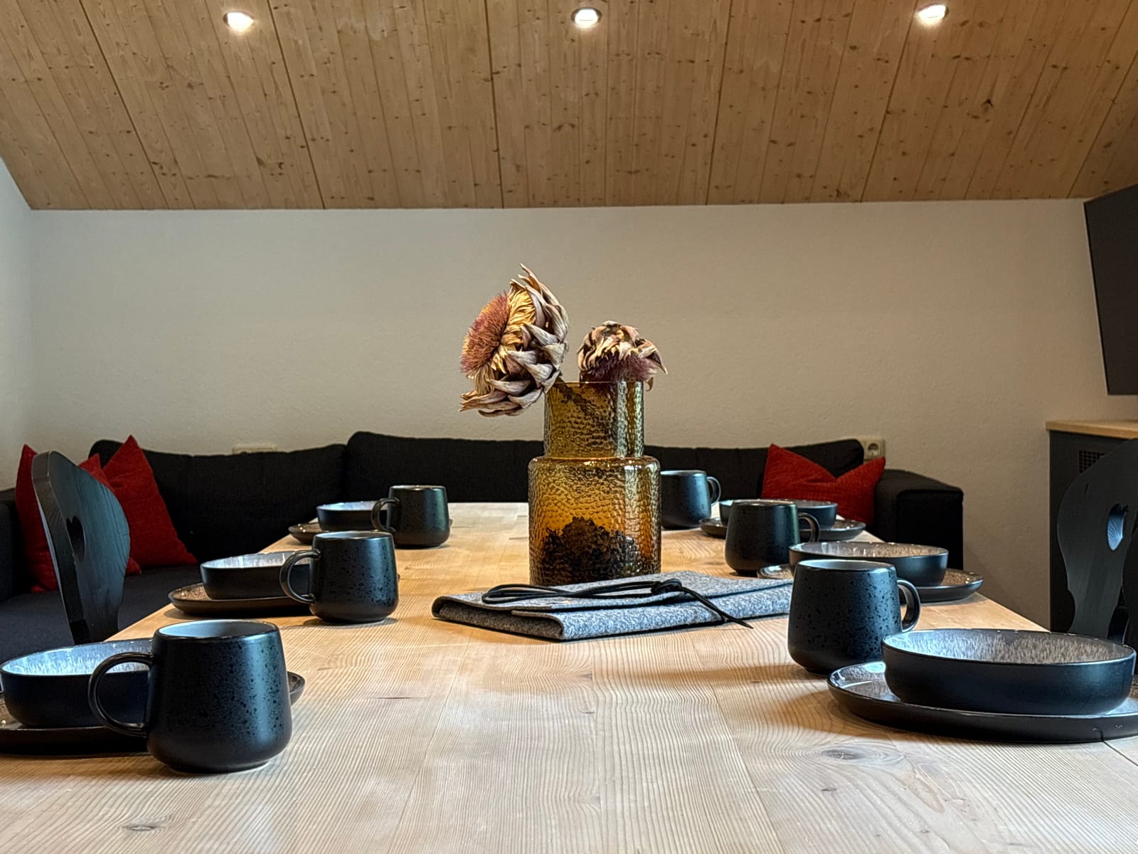 Gedeckter Tisch mit schwarzem Geschirr und Sofa, Detailaufnahme – MONTAFONLodge