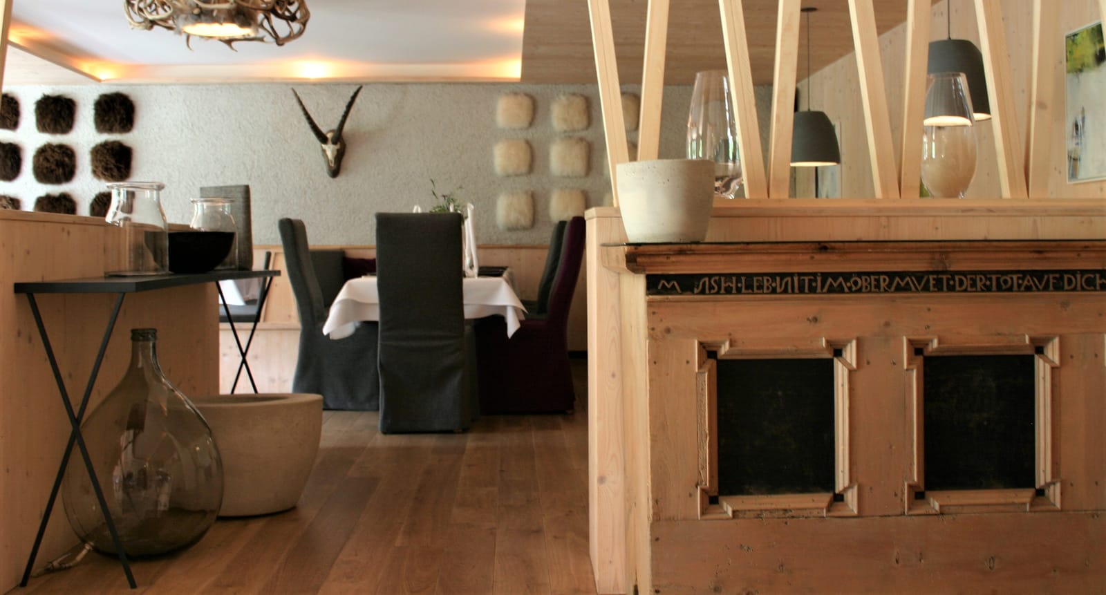 Restaurant mit eingedeckten Tischen, Geweih-Deko und Kreidetafeln – MONTAFONLodge
