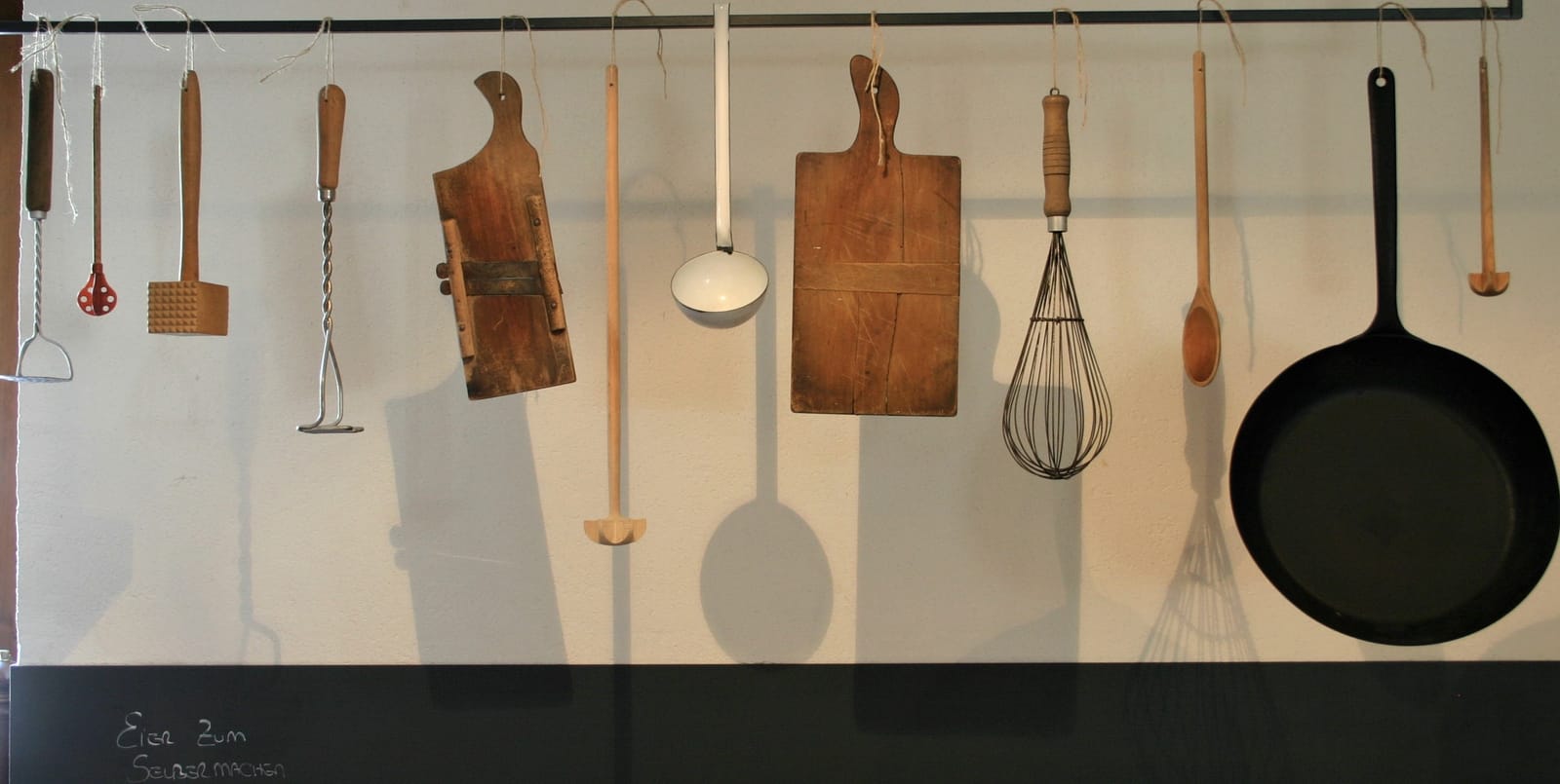 Alte Küchenwerkzeuge und Kochlöffel an der Wand, Deko-Detail – MONTAFONLodge