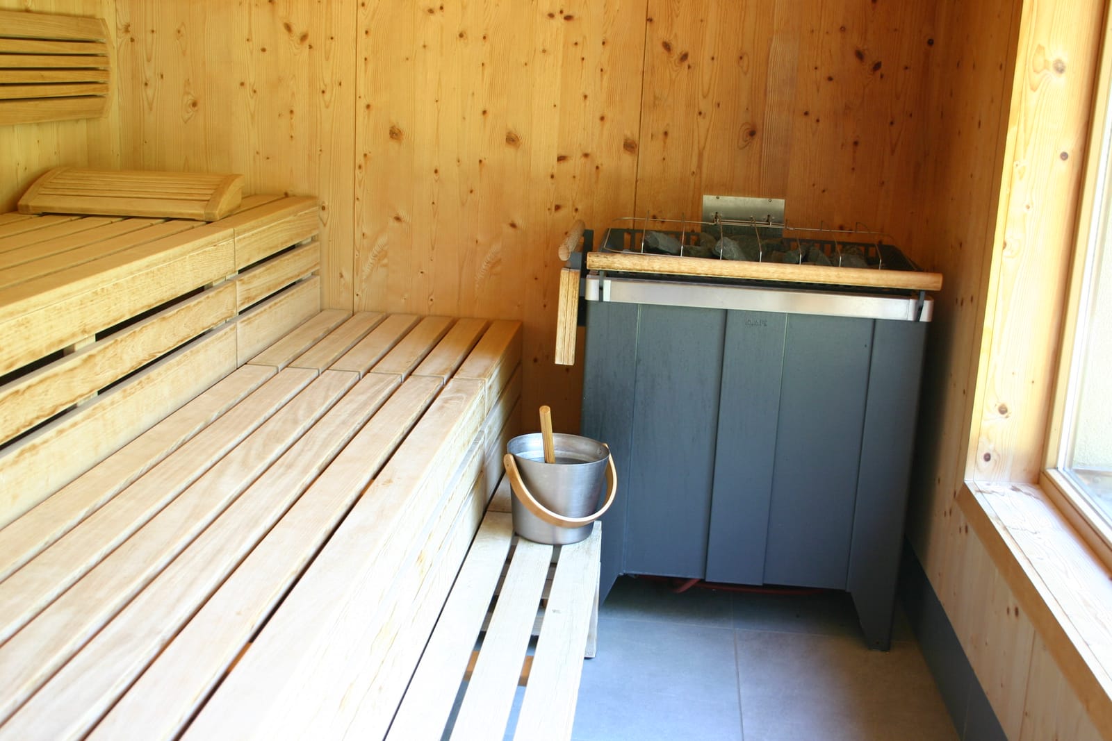 Sauna-Innenraum mit Holzbänken und Aufguss-Kübel – MONTAFONLodge