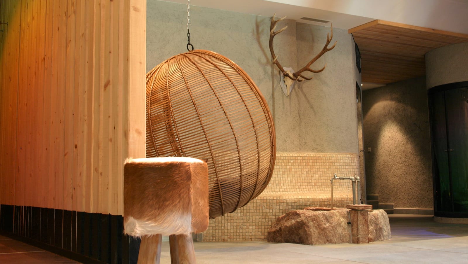 Rattan-Hängesessel und Fell-Hocker im Spa – MONTAFONLodge