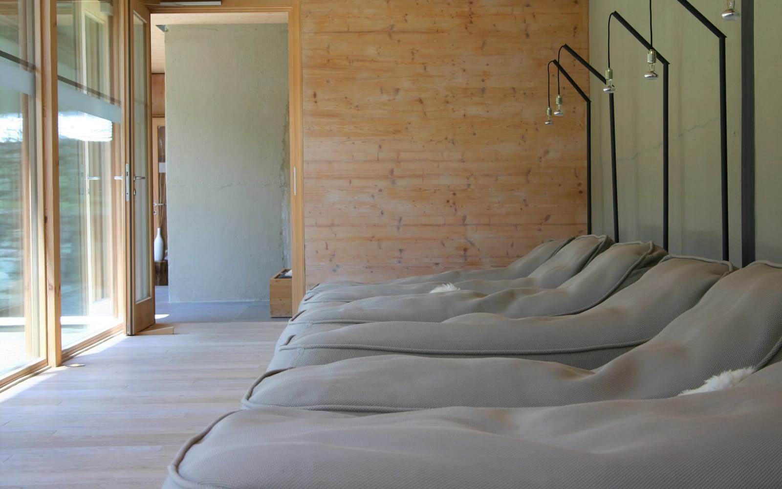 Ruheraum mit gepolsterten Liegen an Holzwand – MONTAFONLodge