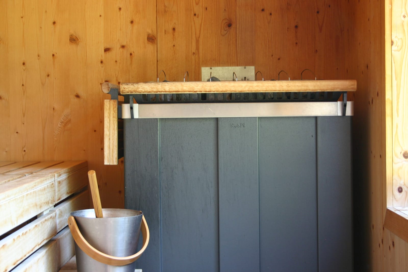 Sauna-Innenraum mit Aufguss-Kübel und Holzbänken – MONTAFONLodge