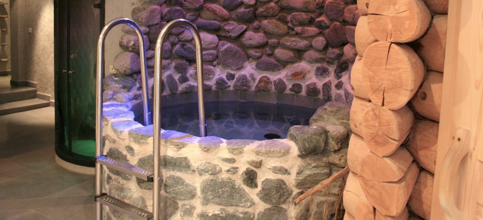 Beleuchteter Stein-Whirlpool mit Edelstahlleiter – MONTAFONLodge