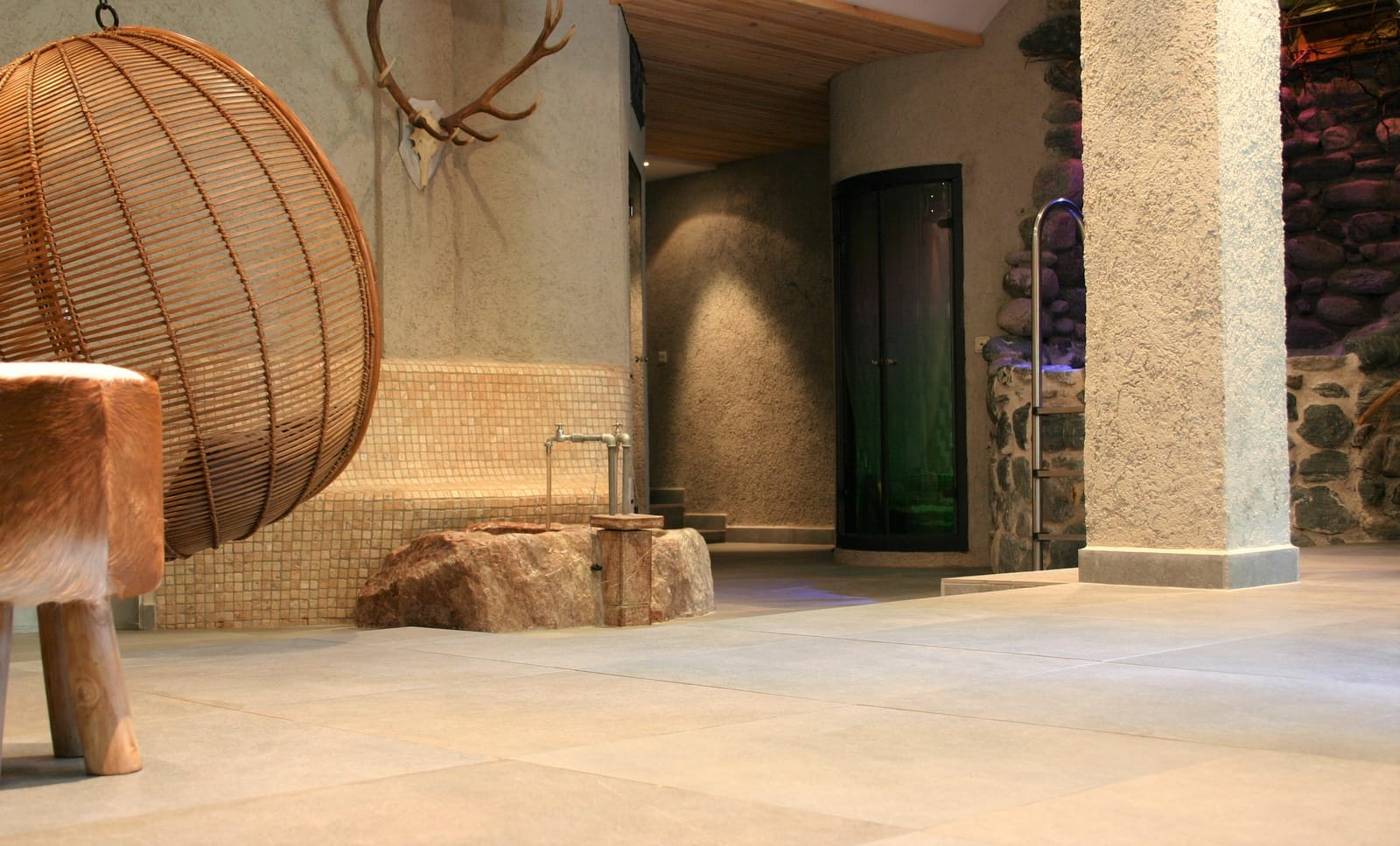Rattan-Hängesessel und Geweih an der Wand im Spa – MONTAFONLodge