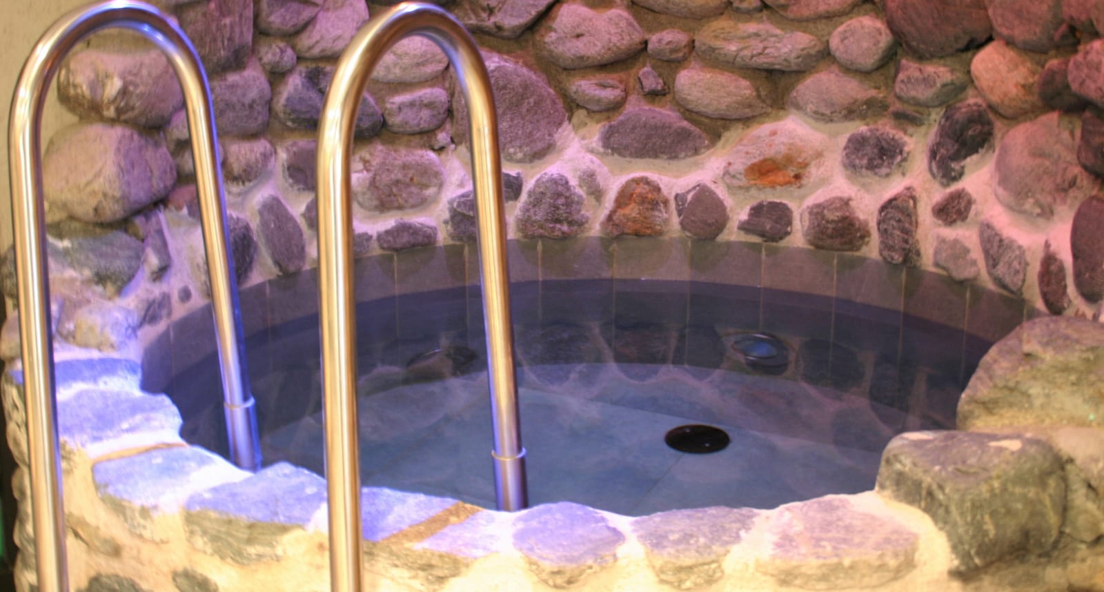 Beleuchteter Stein-Whirlpool mit Steinmauer – MONTAFONLodge