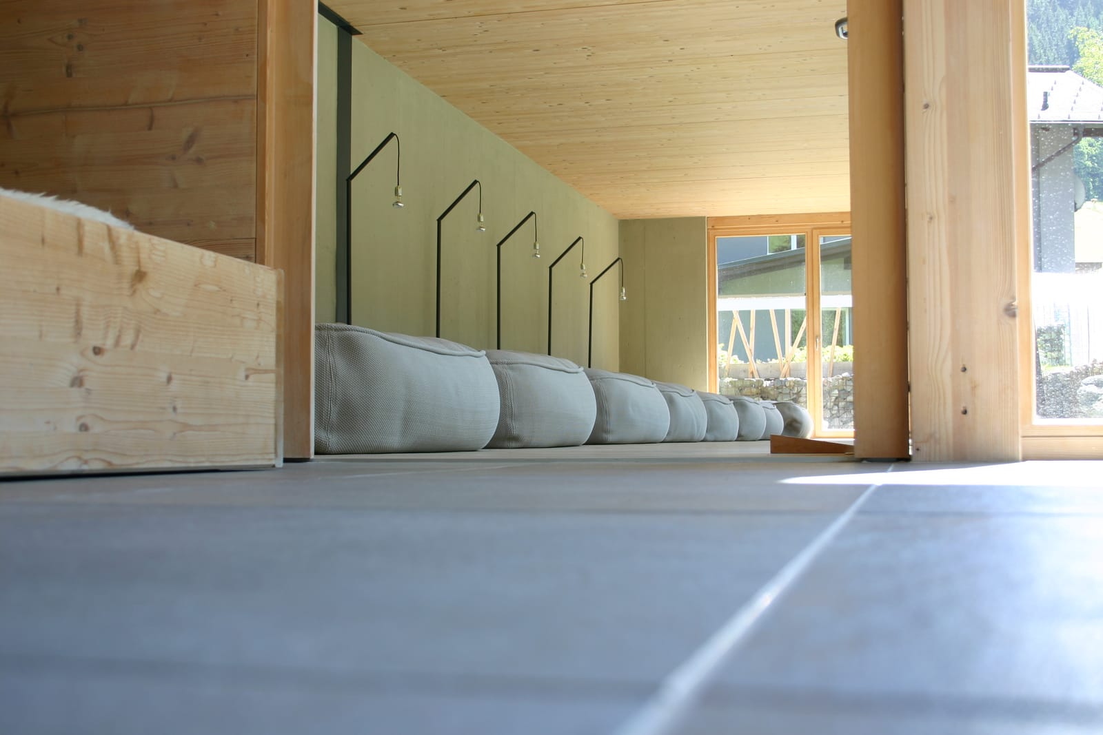 Ruheraum mit Liegenreihe unter Dachschräge – MONTAFONLodge