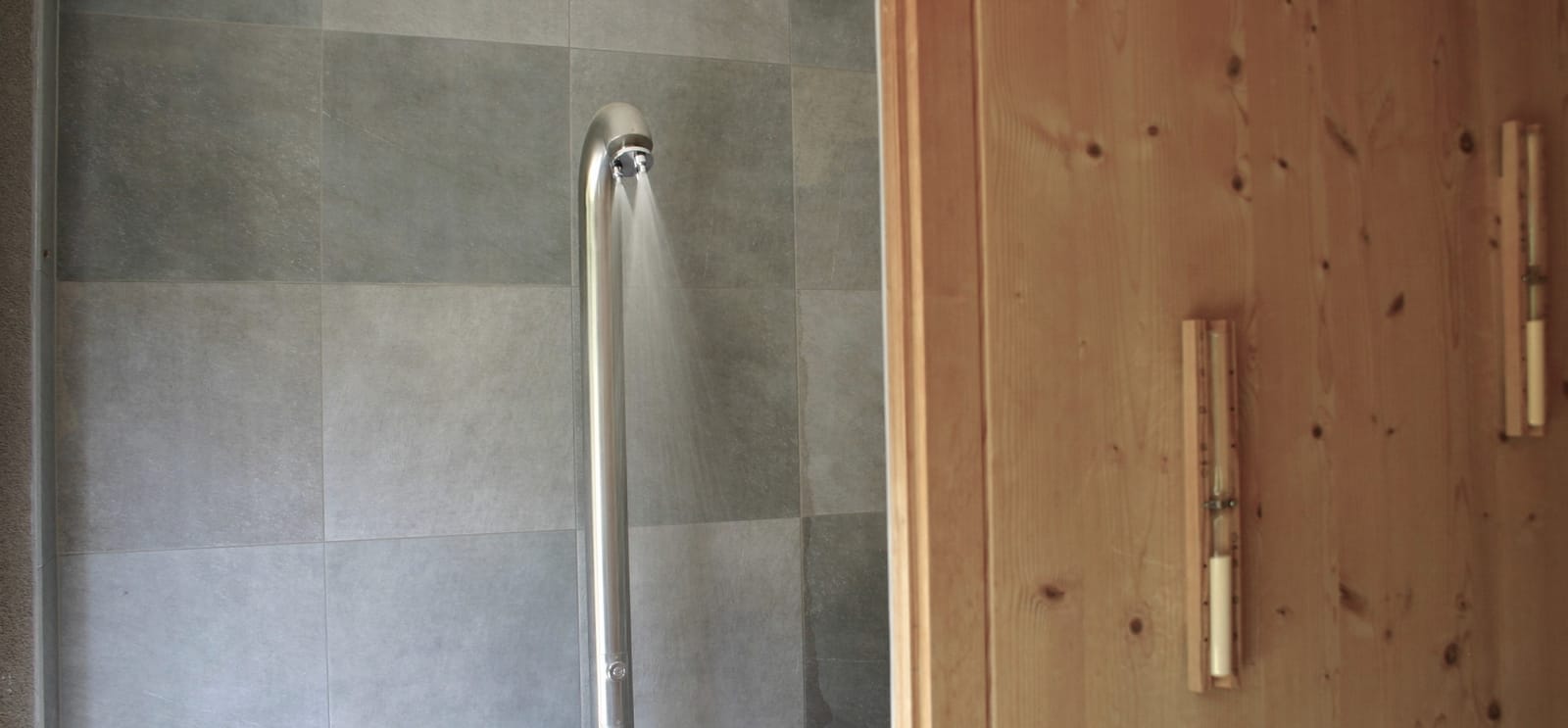 Dusche mit Edelstahl-Brause und Fliesen – MONTAFONLodge
