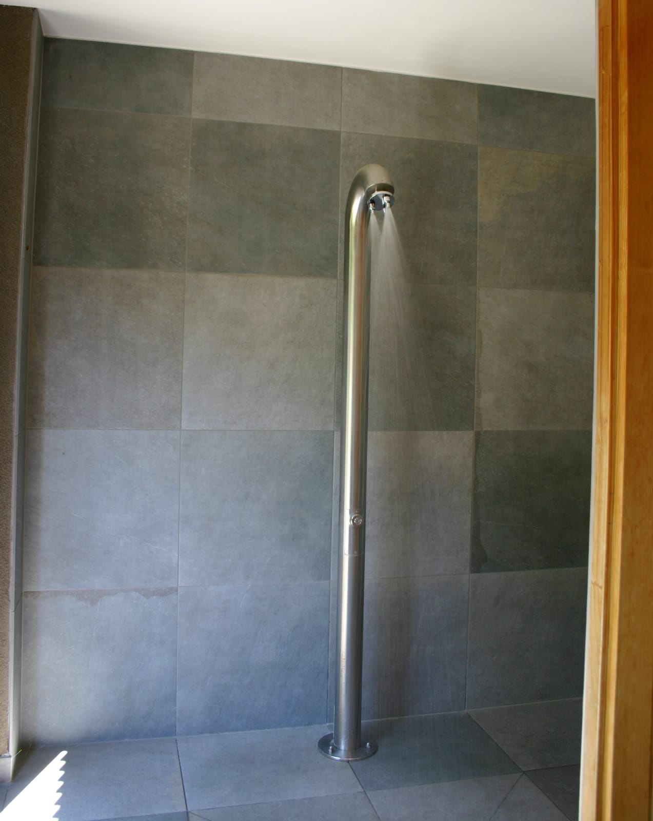 Dusche mit Edelstahl-Brause und Fliesen – MONTAFONLodge