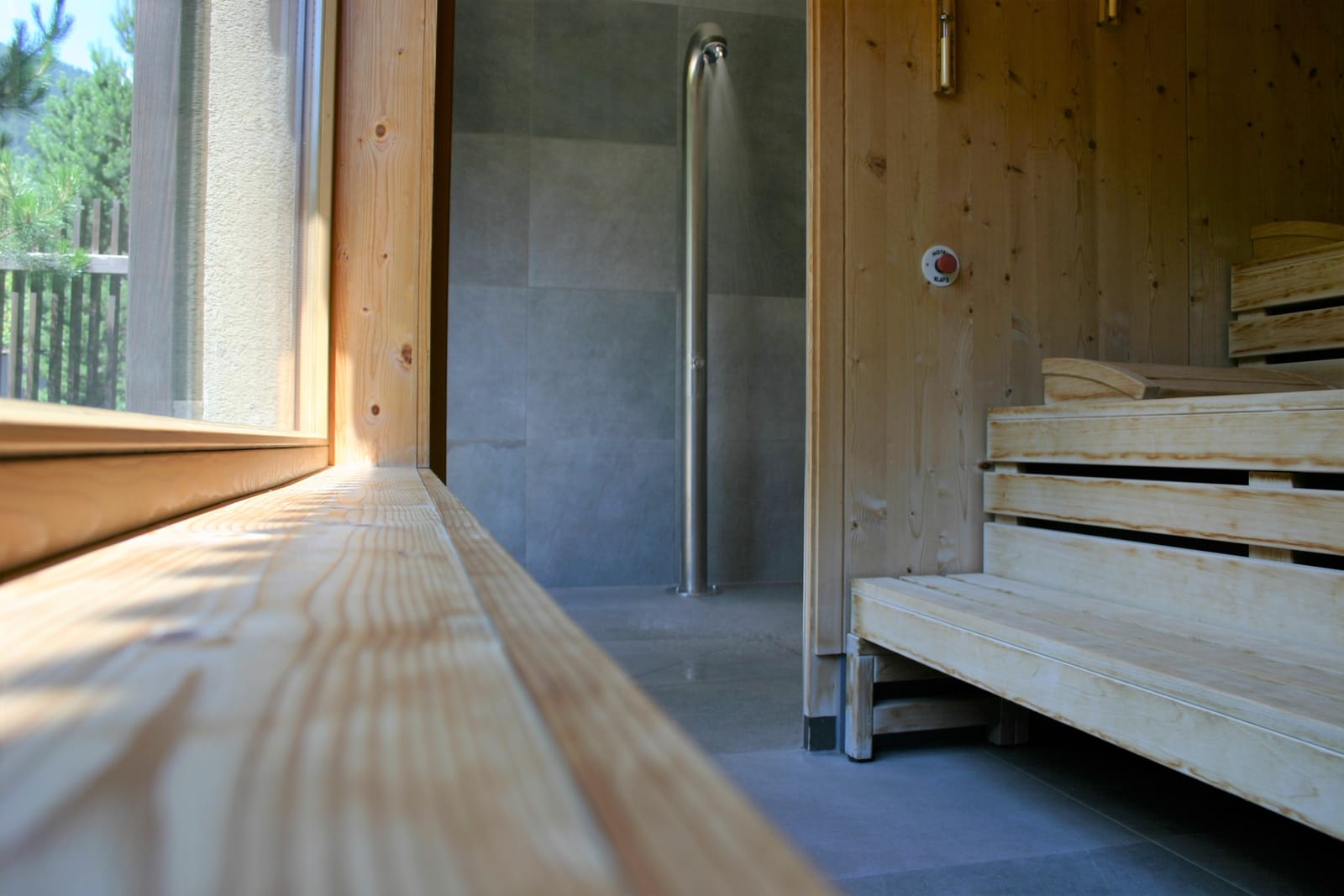 Sauna-Innenraum mit Holzbank und Edelstahl-Brause – MONTAFONLodge
