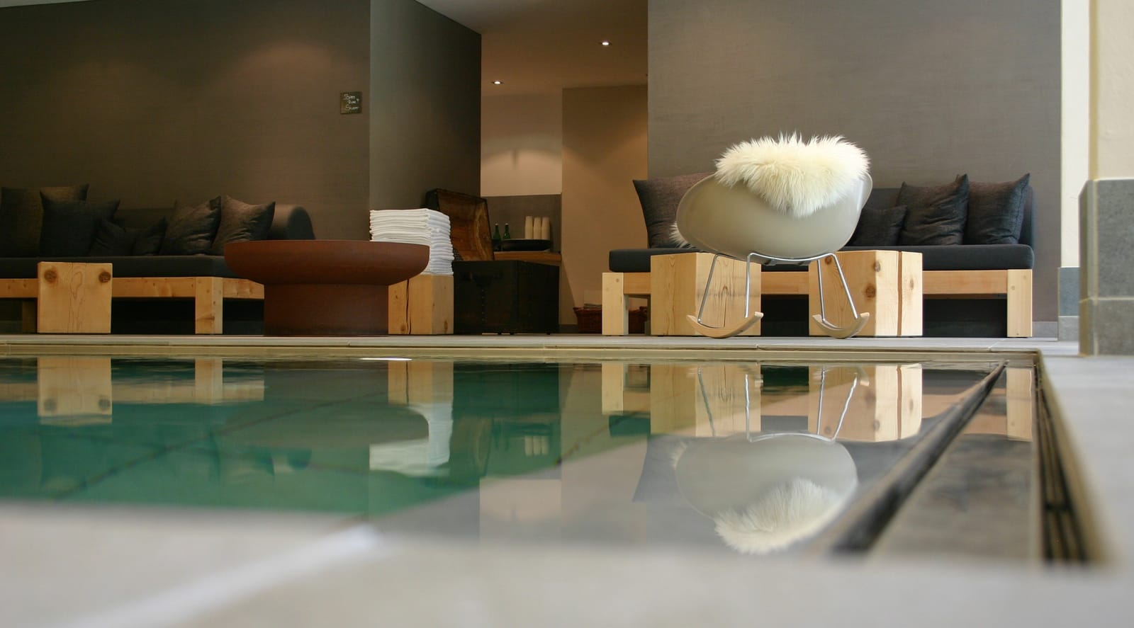 Innenpool mit Ruheliegen und Schaffell – MONTAFONLodge