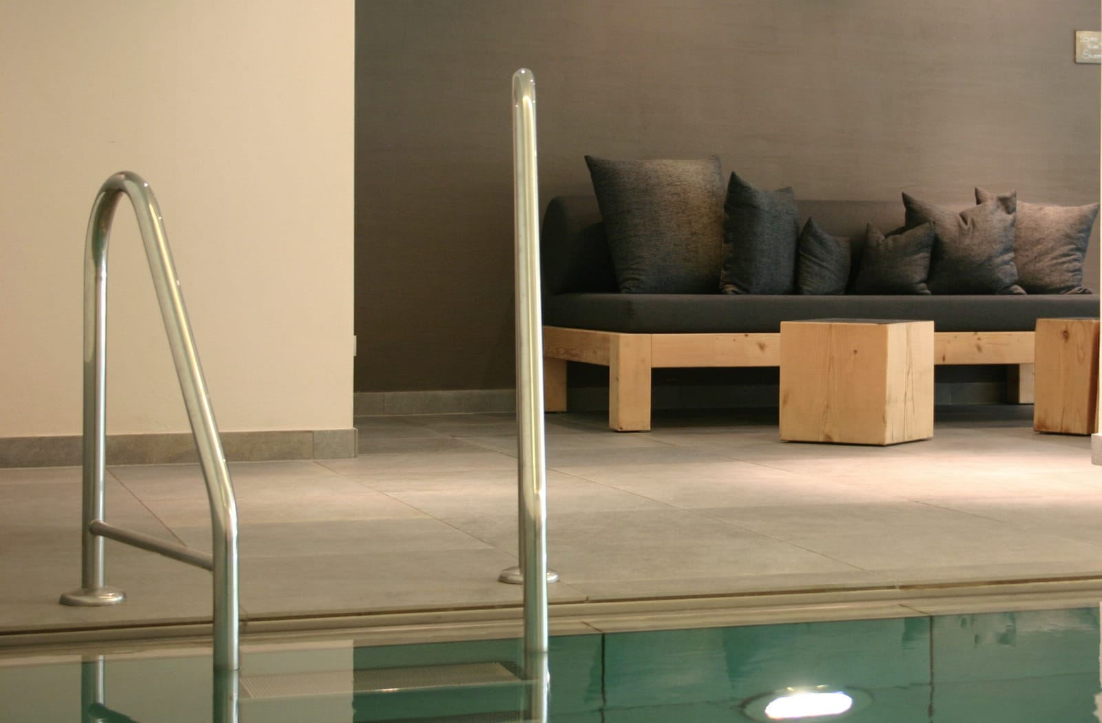 Edelstahl-Poolleiter und Sitzbank mit Kissen am Innenpool – MONTAFONLodge