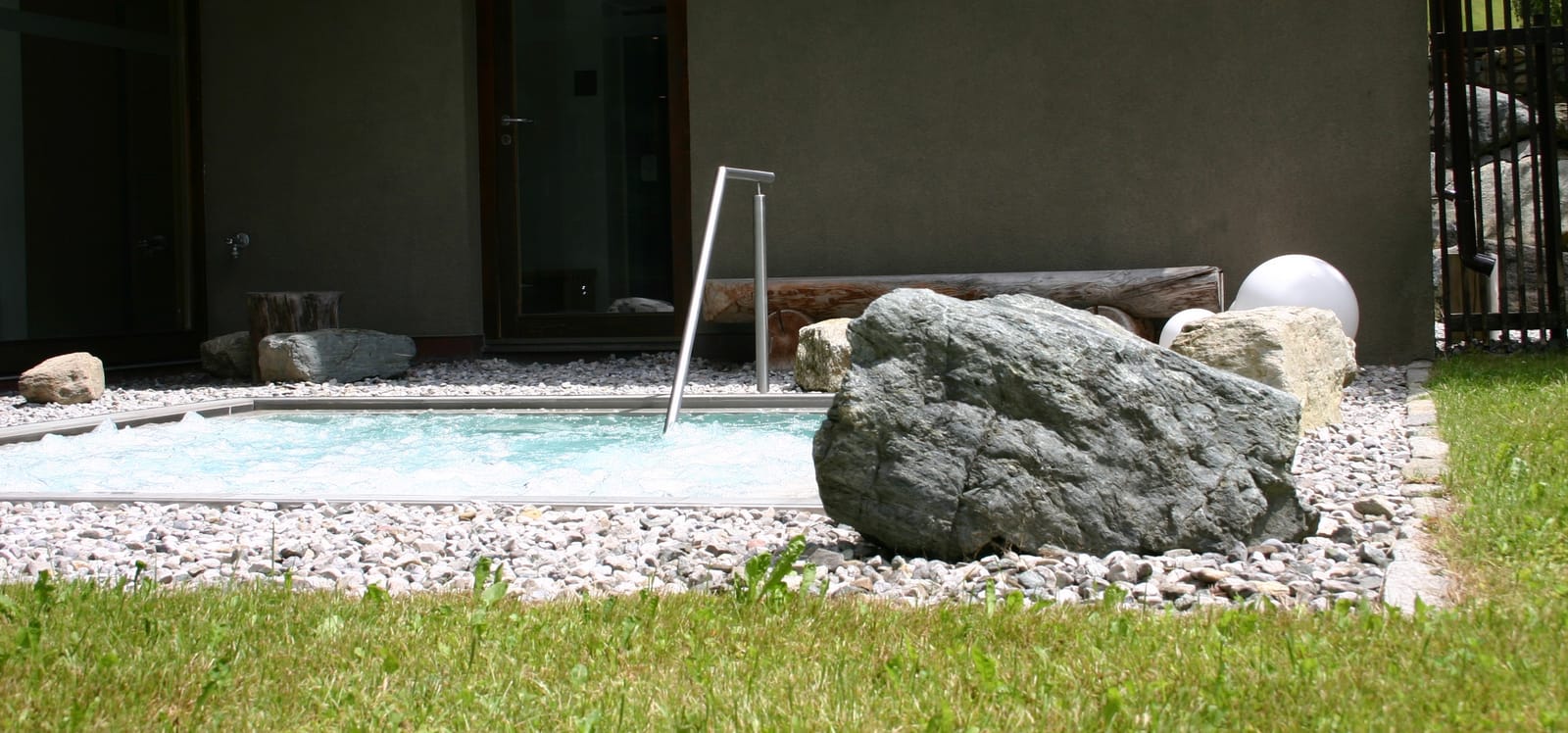 Außenbereich mit Findling und Wasserlauf im Garten – MONTAFONLodge