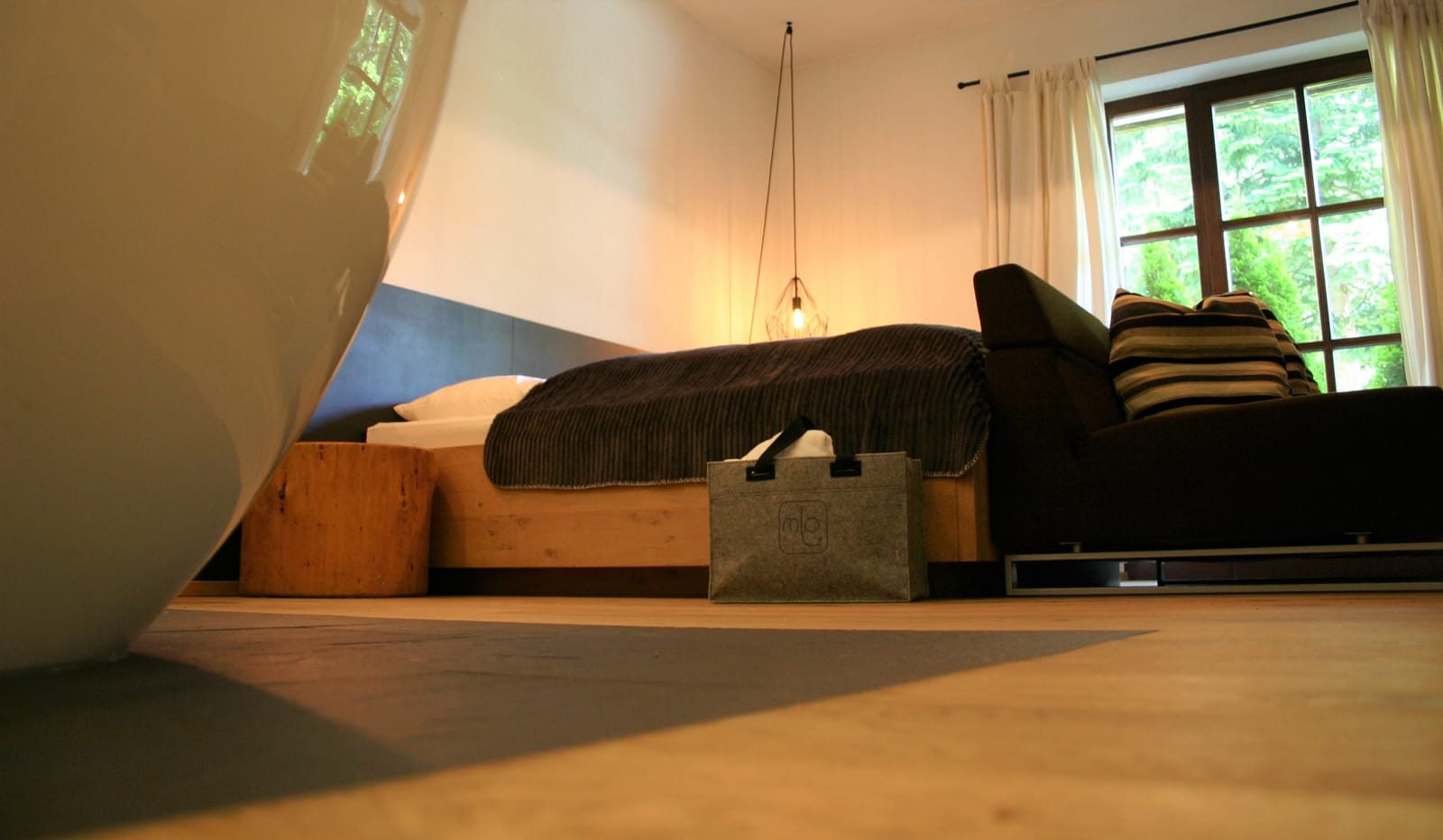 Doppelbett mit Filztasche, Blick zum Fenster – MONTAFONLodge