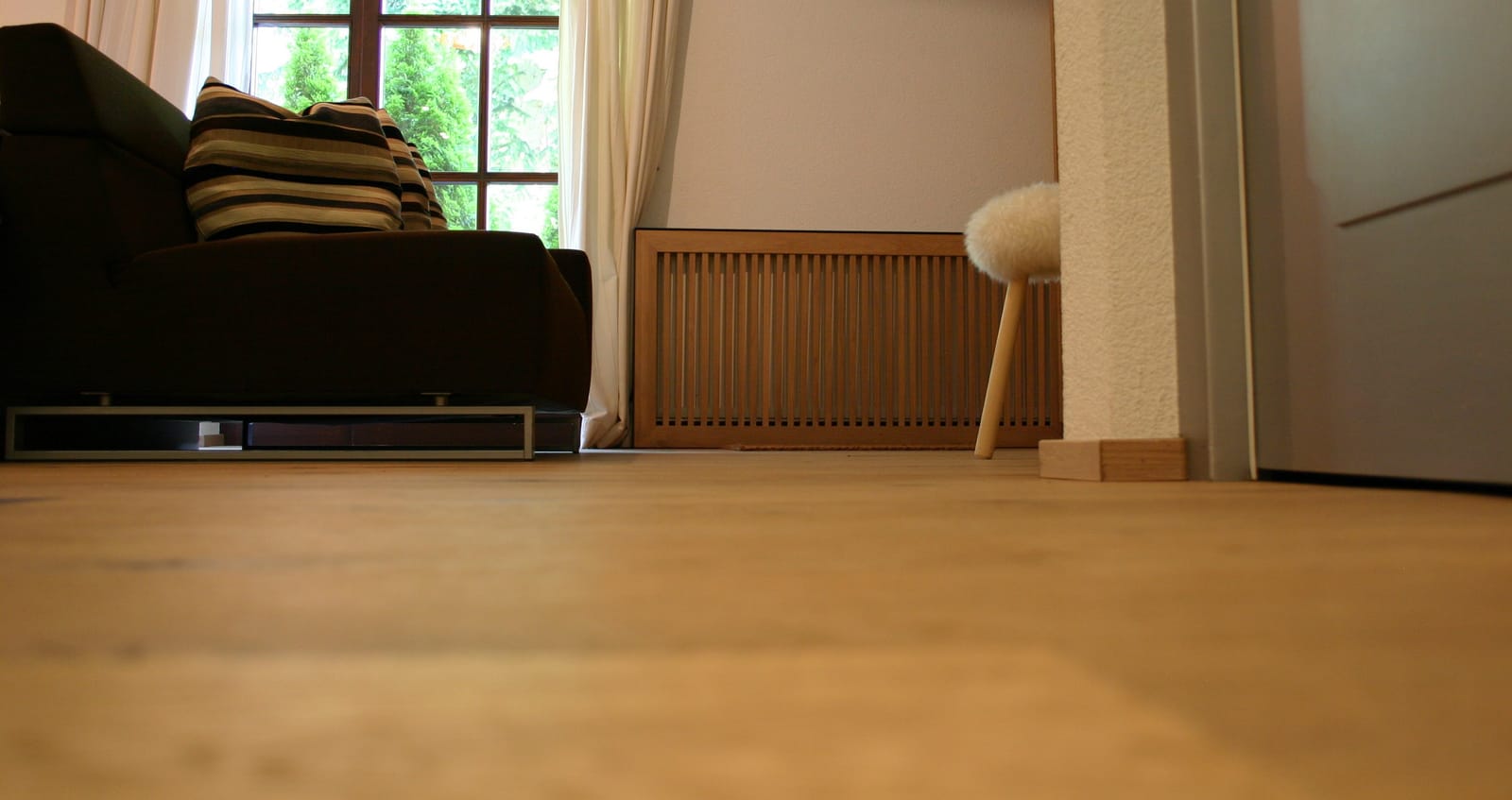 Zimmerecke mit Heizkörper-Holzverkleidung und Hocker – MONTAFONLodge