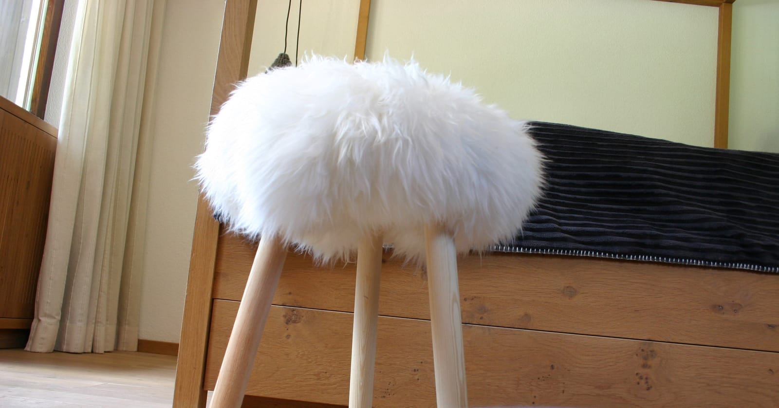Schaffell-Hocker am Bettende, Detailaufnahme – MONTAFONLodge